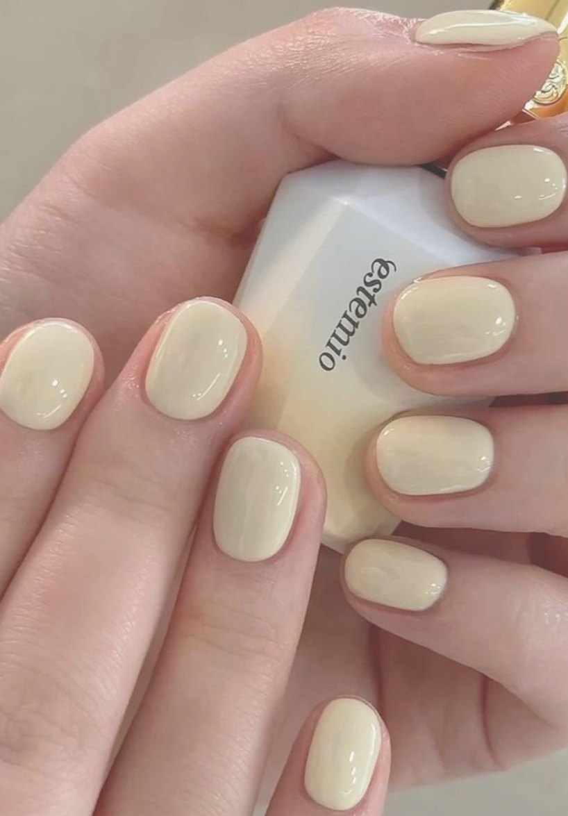 Soft butter-yellow gel manicure on short rounded nails